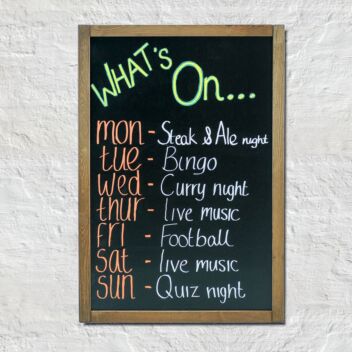Rustic chalkboard with brown stained frame used as a 'what's on this week' board at a pub